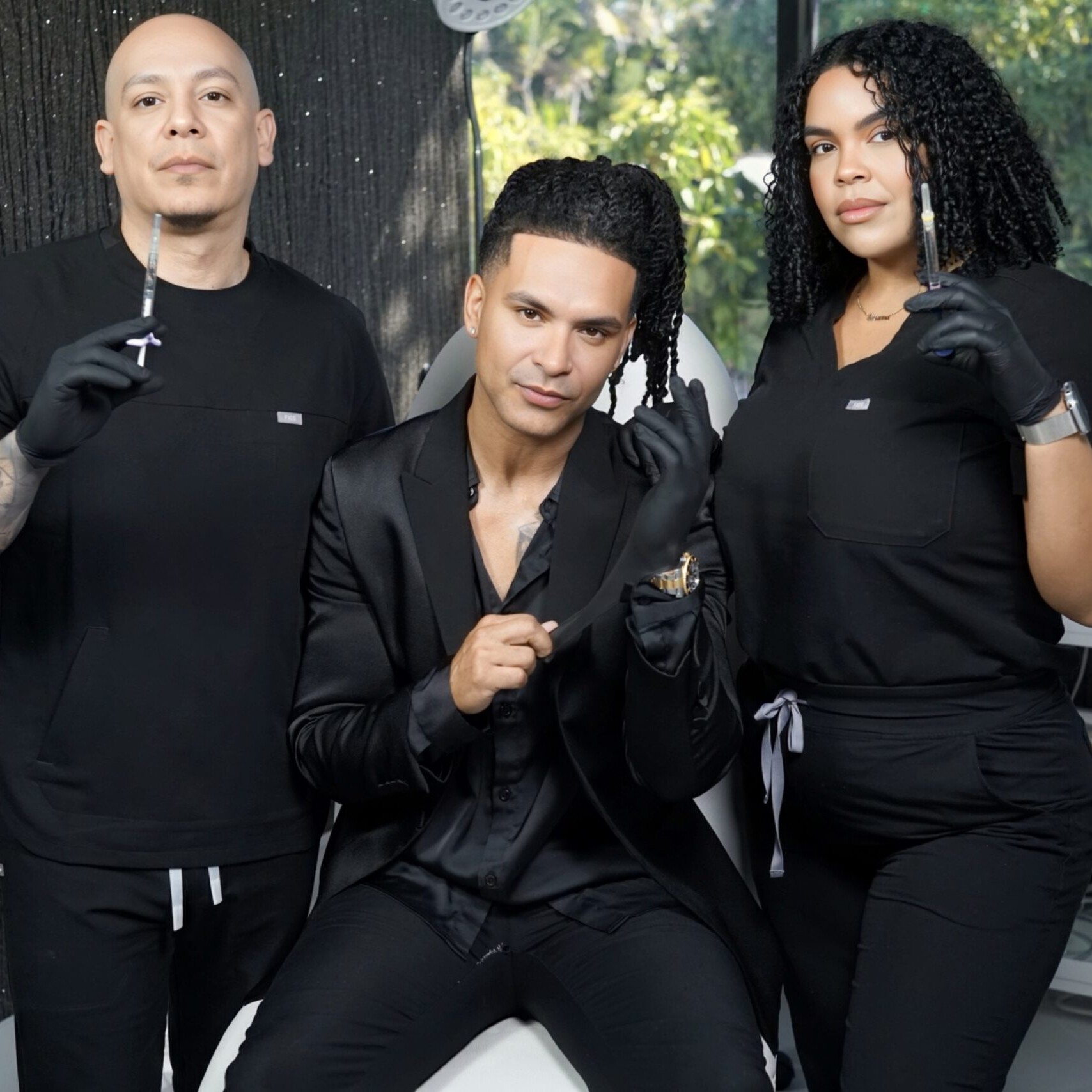Three people in a beauty salon hold aesthetic tools